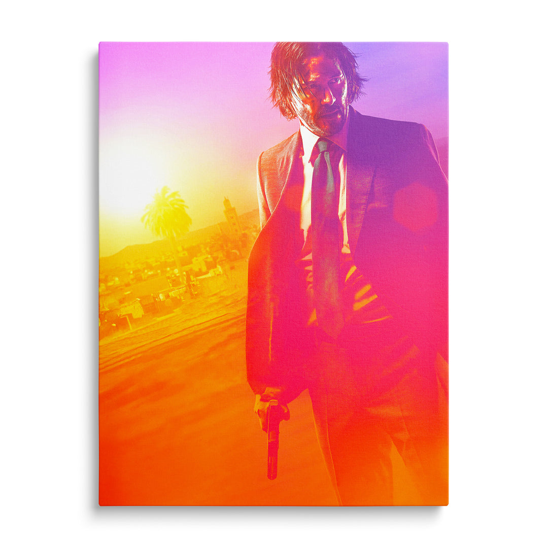John Wick v obleku s pistolí u nohy v pouštní krajině s palmou a budovami, žlutooranžový až růžovopurpurový přechod.