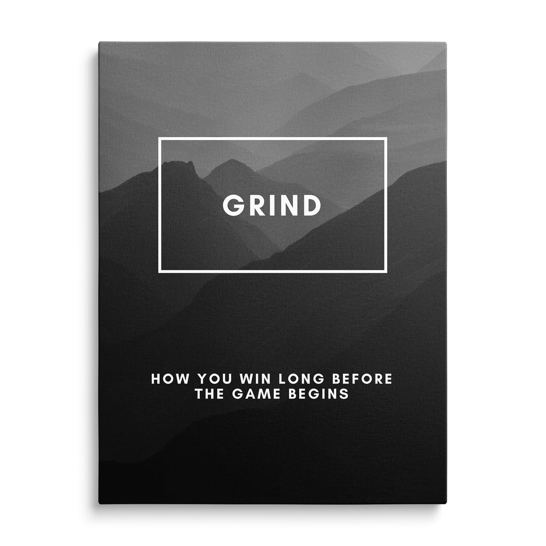 Velké bílé slovo Grind v obdélníkovém rámu na pozadí vrstev šedých hor, dole text How You Win Long Before the Game Begins.