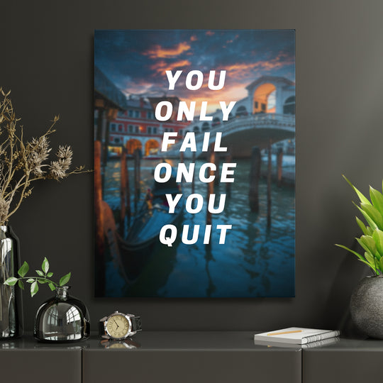 Motivační obraz - You Only Fail Once You Quit v interiéru s hodinami.