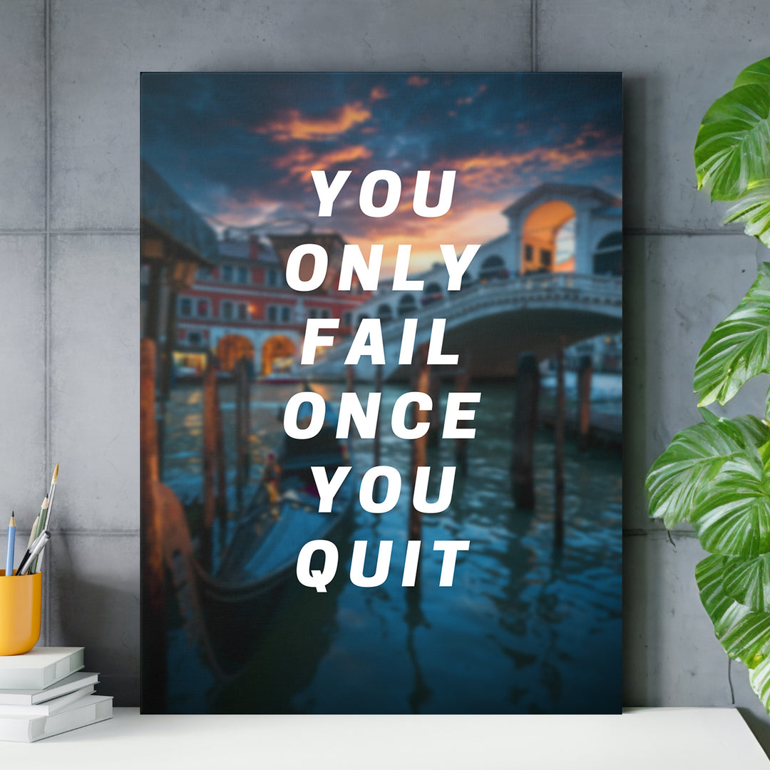 Motivační obraz - You Only Fail Once You Quit nad pracovním stolem.