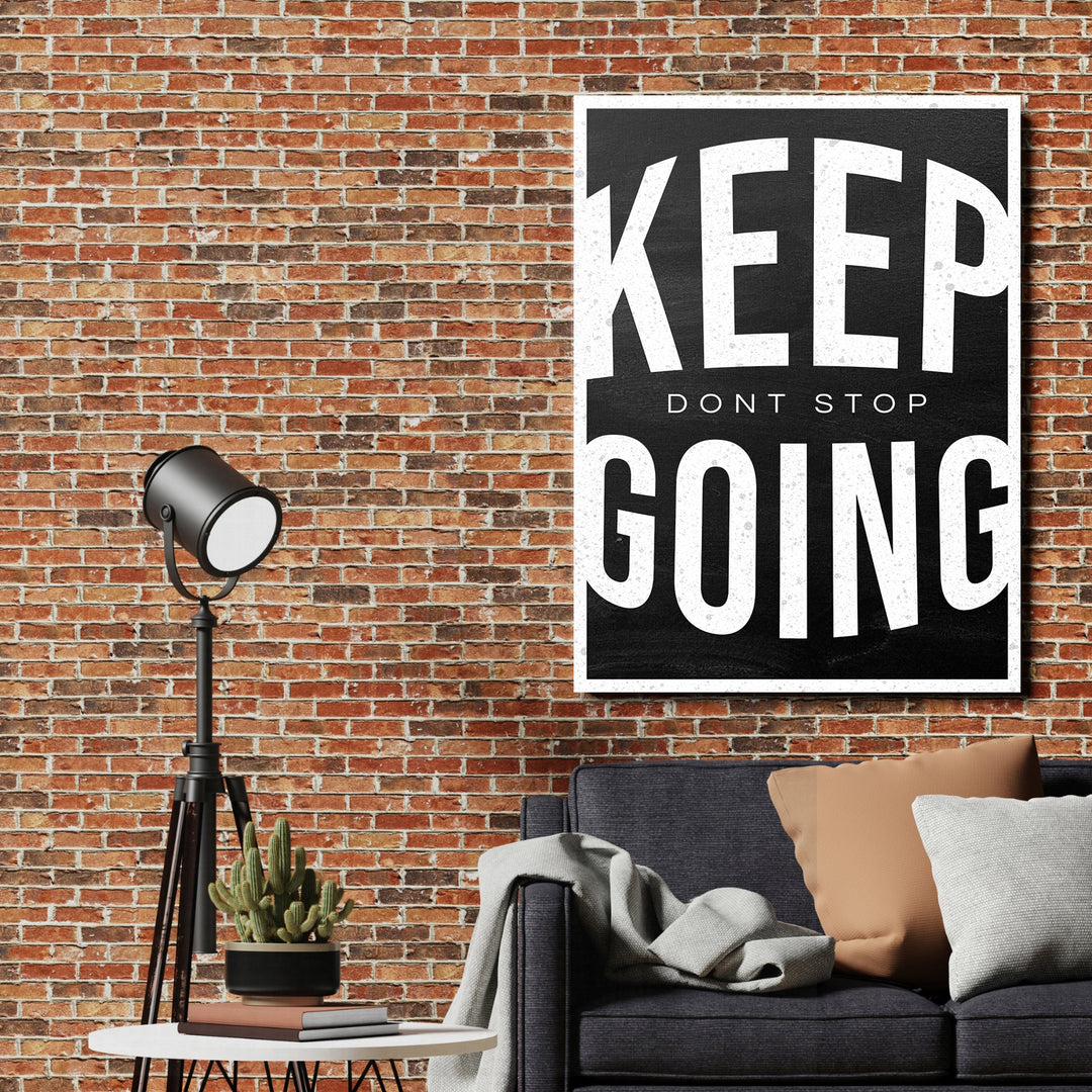 Motivační obraz Keep Going - Vintage typografie na cihlové zdi.