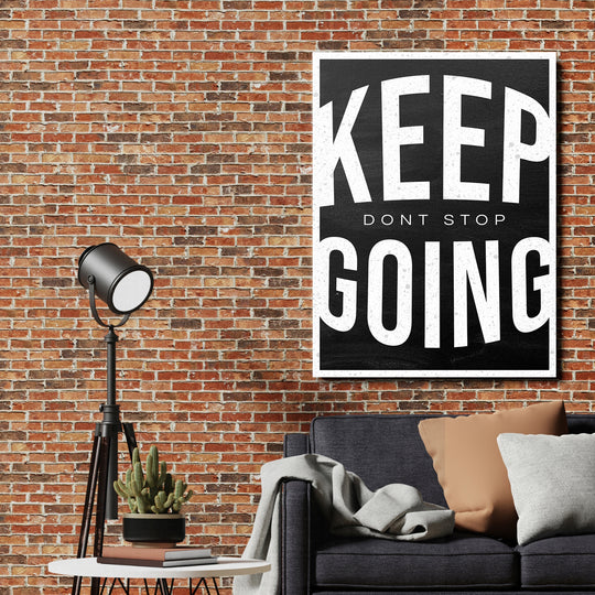Motivační obraz Keep Going - Vintage typografie na cihlové zdi.