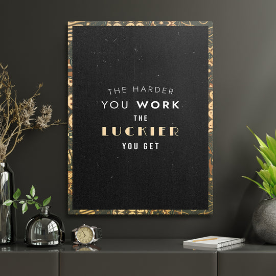 Motivační obraz - The Harder You Work v interiéru s hodinami.