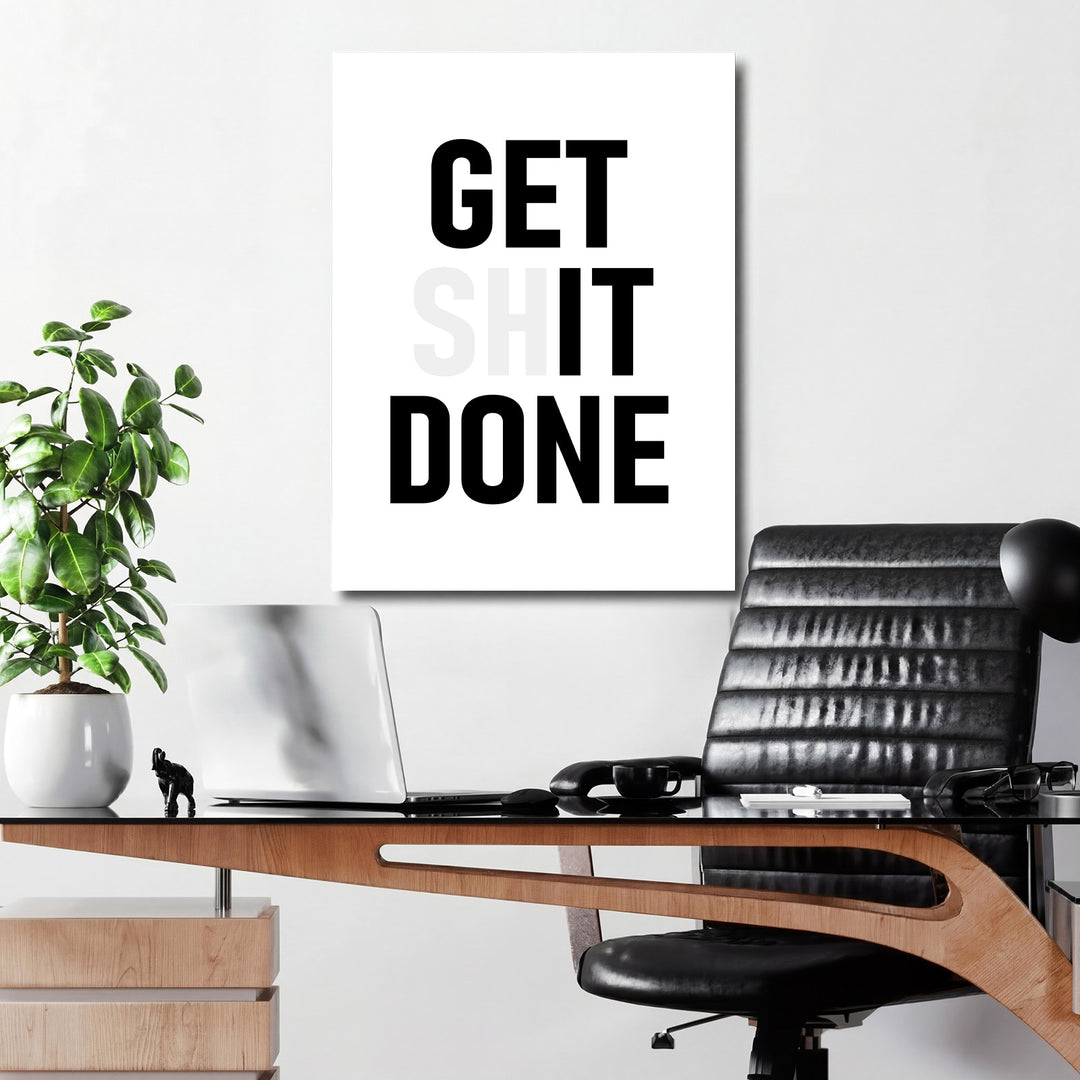 Motivační obraz GET SHIT DONE nad pracovním stolem v moderní kanceláři
