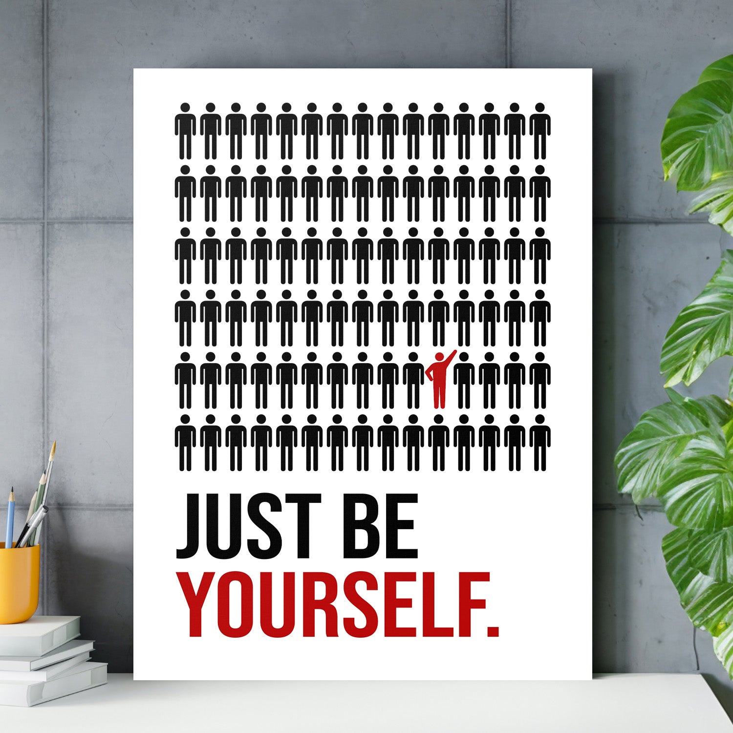 Motivační obraz na plátně s černými figurkami a jednou červenou postavou nad nápisem JUST BE YOURSELF