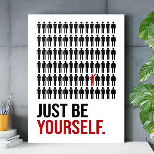 Motivační obraz na plátně s černými figurkami a jednou červenou postavou nad nápisem JUST BE YOURSELF