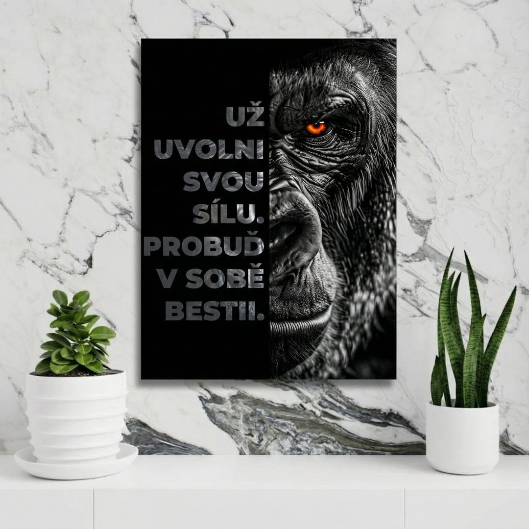 Motivační obraz na zeď s černobílou gorilou s oranžovým okem a citátem, zavěšený nad zelenými pokojovými rostlinami