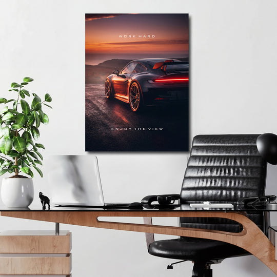 Motivační obraz na zeď s luxusním sportovním autem v moderní pracovně při dramatickém západu slunce