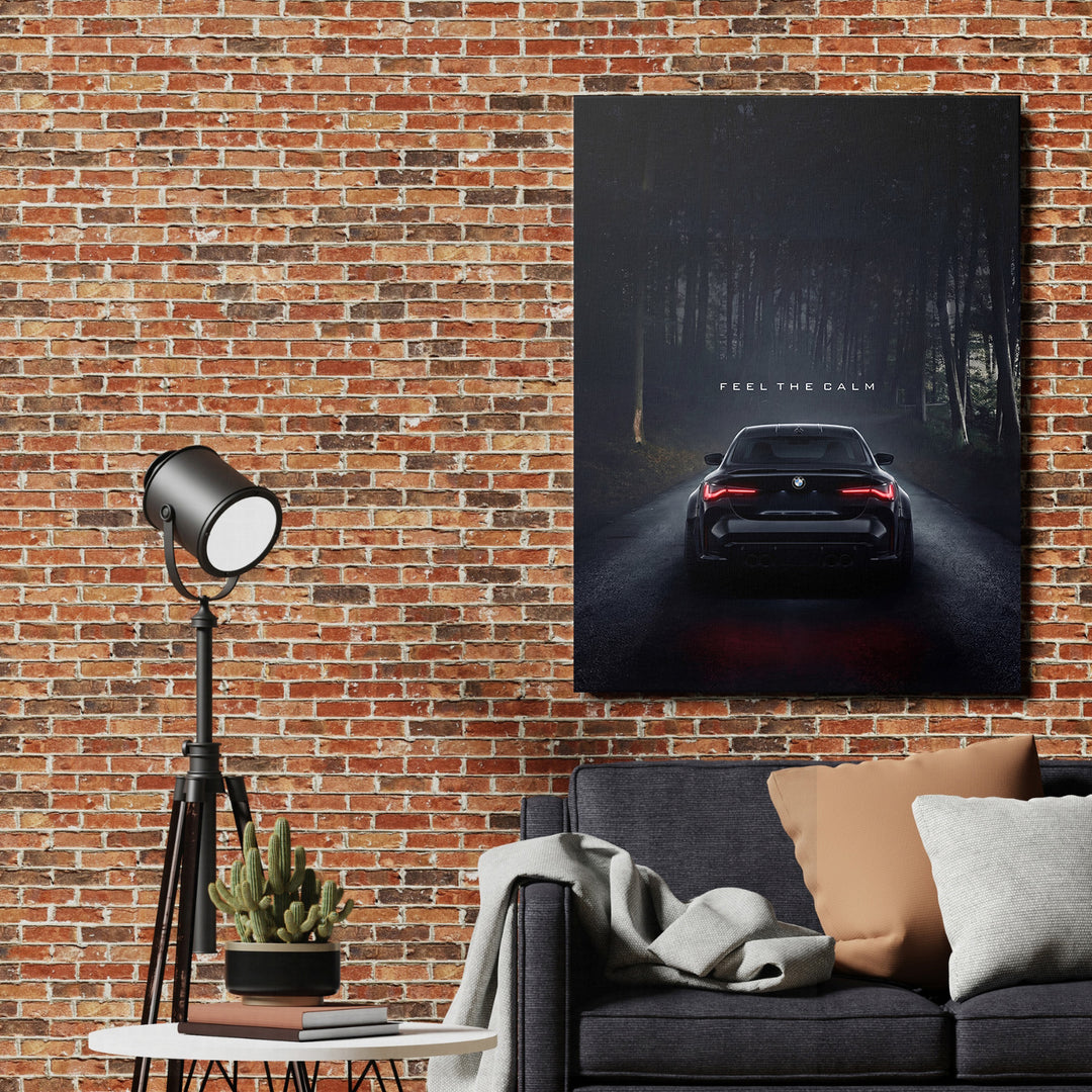 Motivační obraz na plátně s černým BMW na tmavé lesní cestě a citátem Feel the Calm v obývacím pokoji