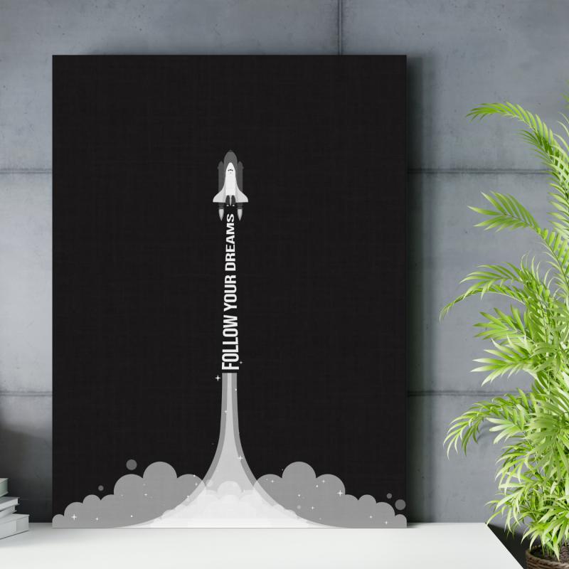 Motivační obraz na zeď s minimalistickou raketou a citátem „Follow your dreams“ v moderní kanceláři