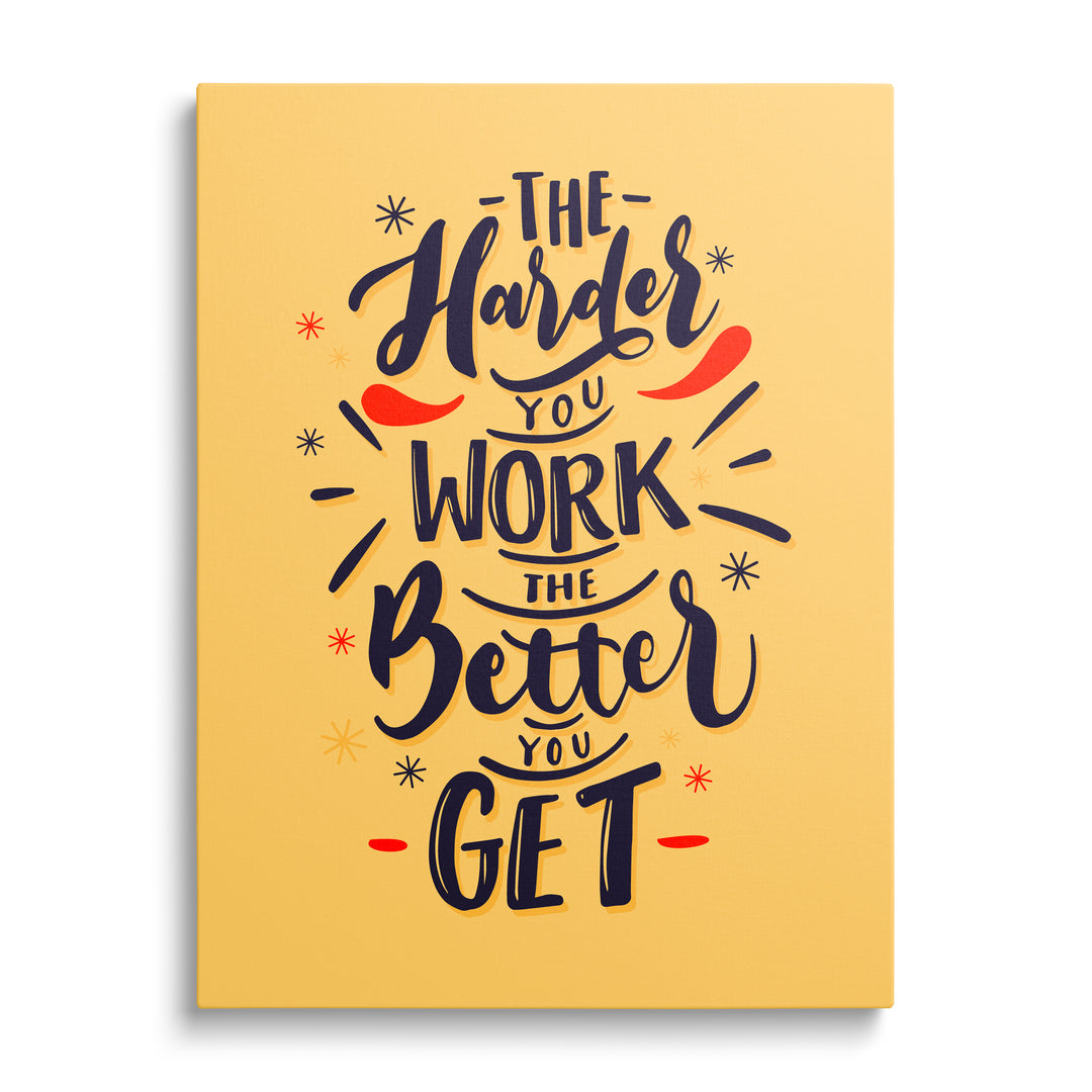 Motivační obraz na plátně s citátem „The harder you work the better you get“ na žlutém pozadí, čelní pohled