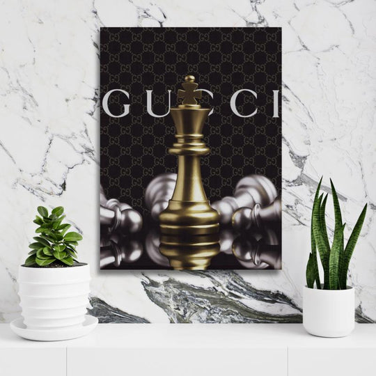Motivační obraz královské šachové figurky s pozadím Gucci na bílé zdi s rostlinou. BudujImperium.cz | motivační obrazy a motivační citáty