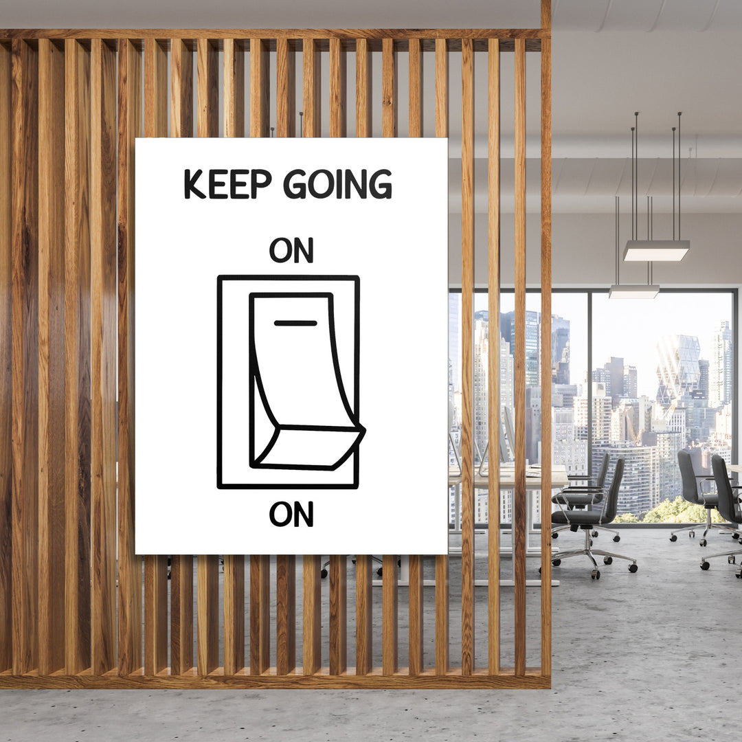 Motivační obraz na zeď s černobílým minimalistickým přepínačem a nápisem KEEP GOING v moderní kanceláři