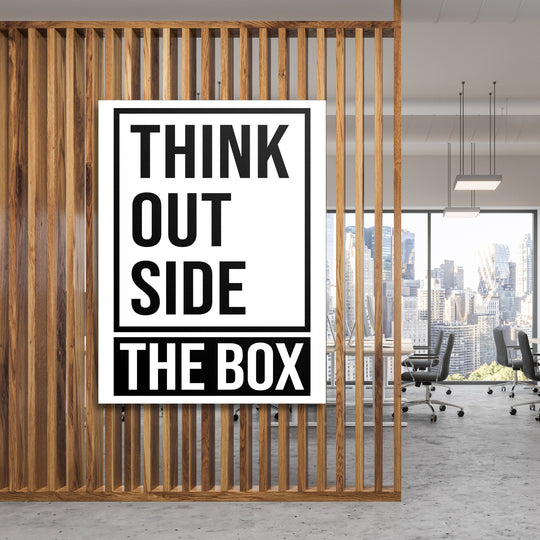 Motivační obraz na plátně s citátem Think outside the box v moderní kanceláři za dřevěnou příčkou
