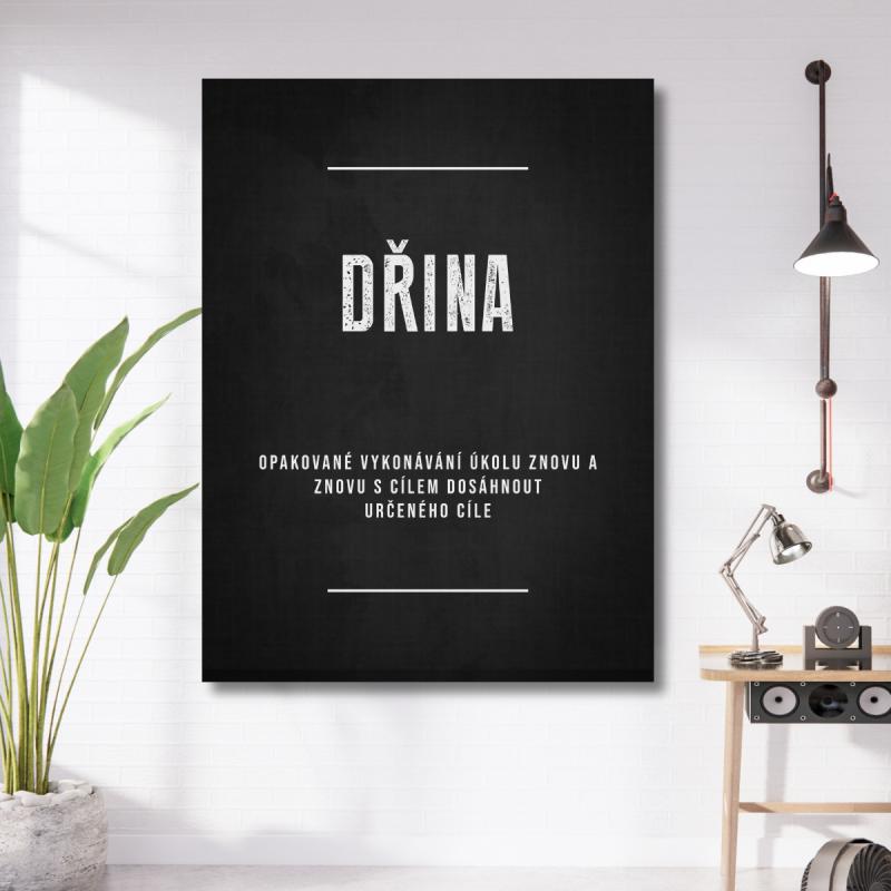 Motivační obraz na plátně s černobílým citátem Dřina v pracovním koutě u stolní lampy a zelené rostliny
