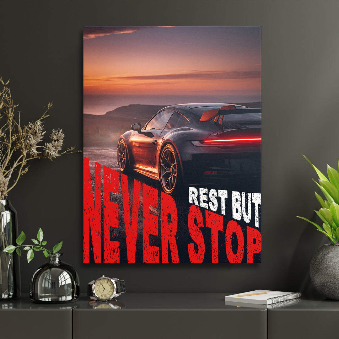 Motivační obraz na zeď s černým sportovním autem při západu slunce a výrazným nápisem Never Stop