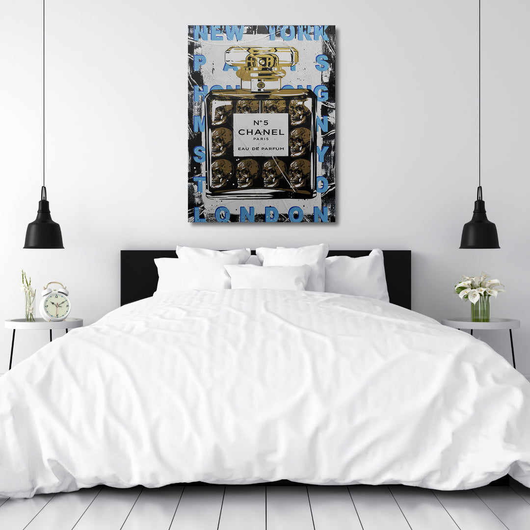 Pop art obraz Chanel No 5 s lebkami v černo‑bílé minimalistické ložnici