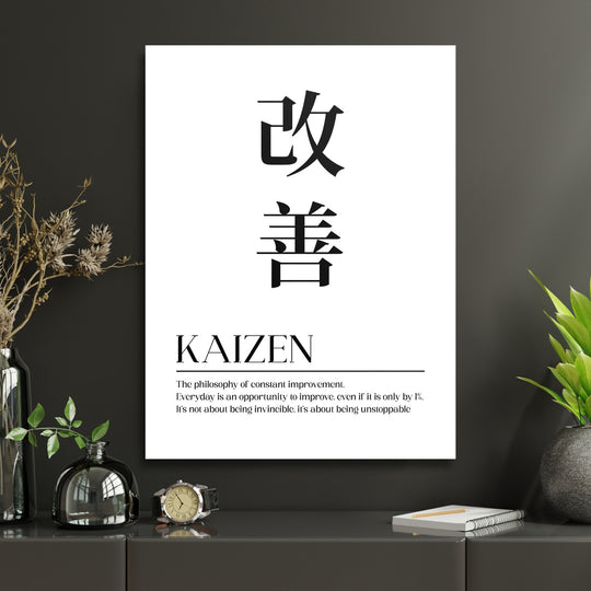 Motivační obraz na plátně Kaizen s japonskými znaky a anglickým citátem na tmavé stěně v interiéru