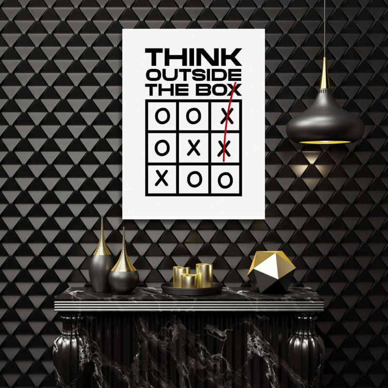 Motivační obraz na zeď v moderní kanceláři s minimalistickým citátem Think Outside the Box a motivem piškvorek